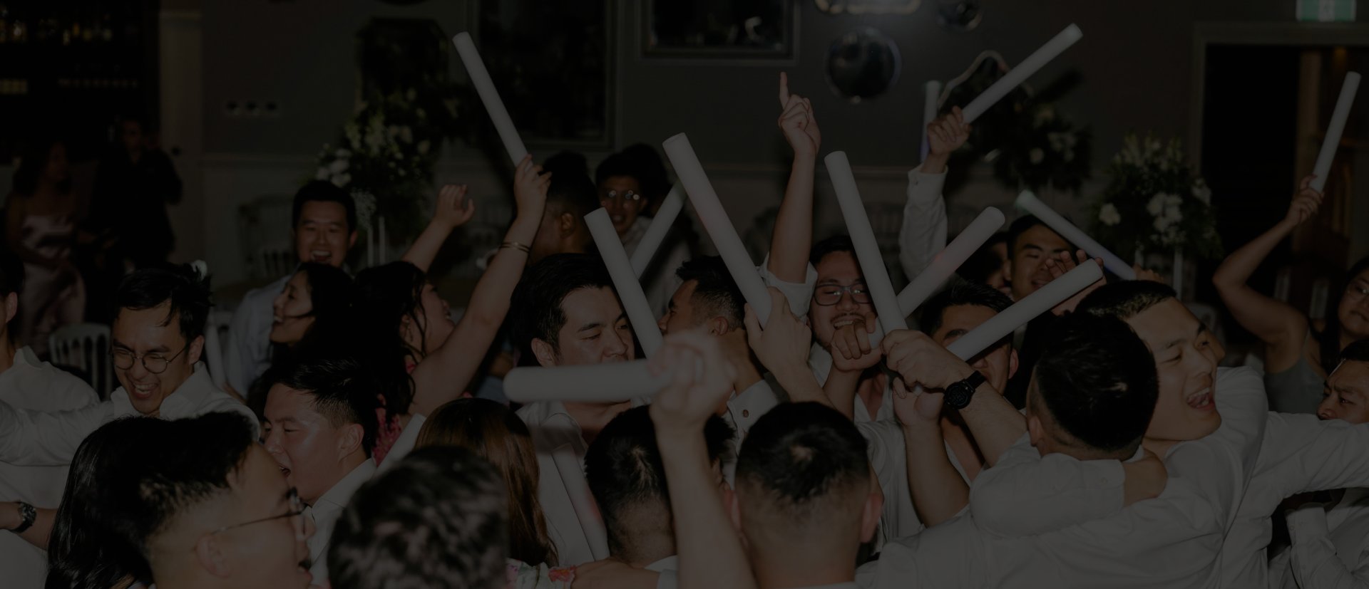 Wedding guests waving glow sticks on the dance floor at a Melbourne reception