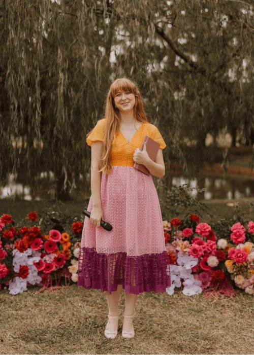 Hester Mary Marries — Melbourne wedding celebrant in colourful dress holding microphone outdoors