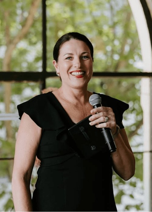 Nat Sproal — Melbourne wedding celebrant smiling with microphone at outdoor ceremony