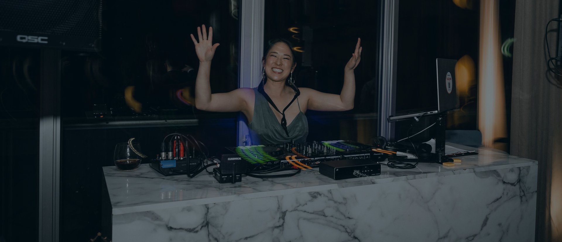 DJ Emily Gracie smiling behind decks at a Melbourne corporate event