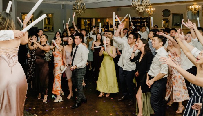 Guests cheering with LED sticks at a lively Melbourne wedding reception — DJ Emily Gracie