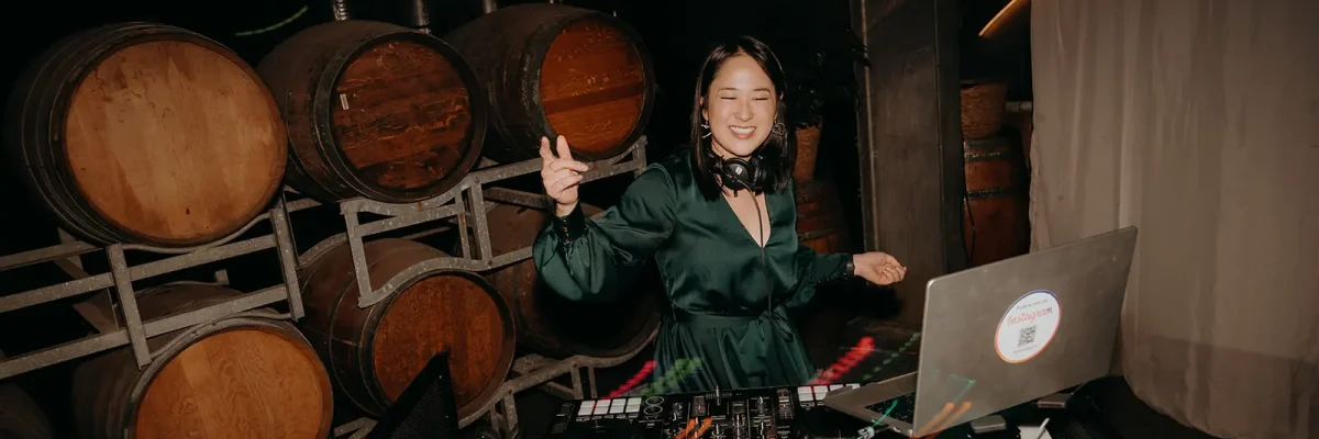 DJ Emily Gracie performing in green dress at a Melbourne winery event