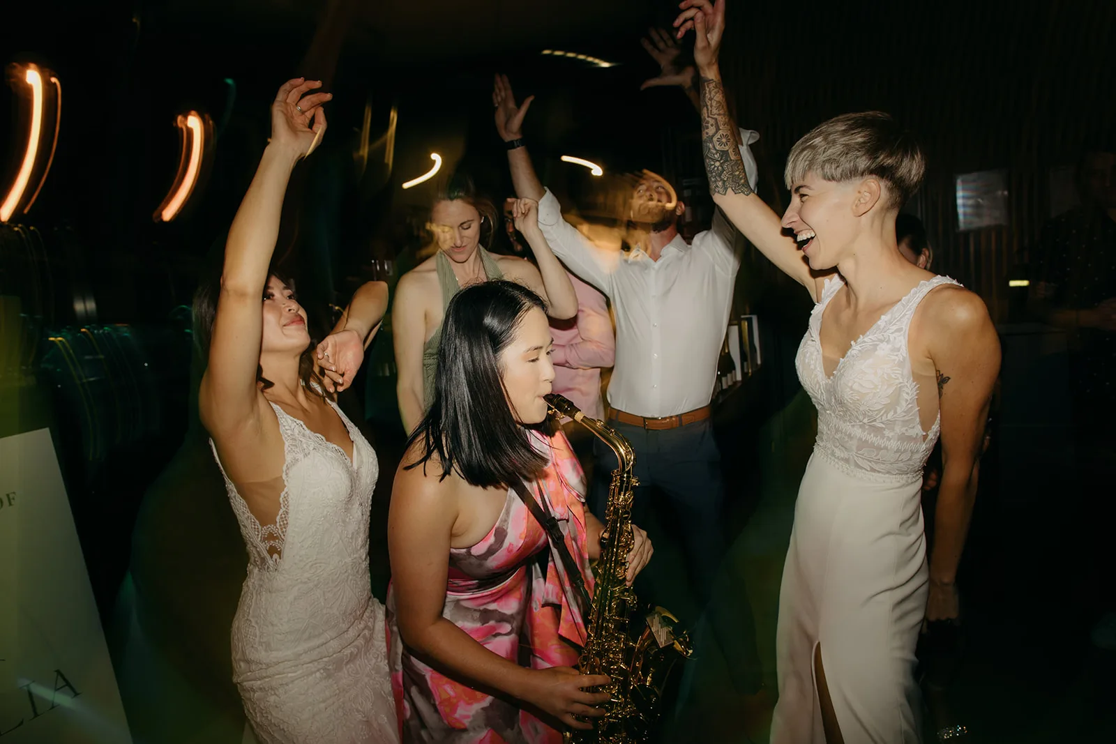 Live saxophone player performing for a same-sex couple on the dance floor at a Melbourne wedding